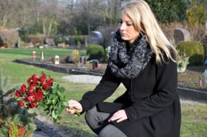 Sad woman bringing red roses for her late mother.