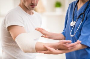 Doctor checking the broken arm of car accident victim.