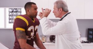 Doctor examining football player for possible brain injury