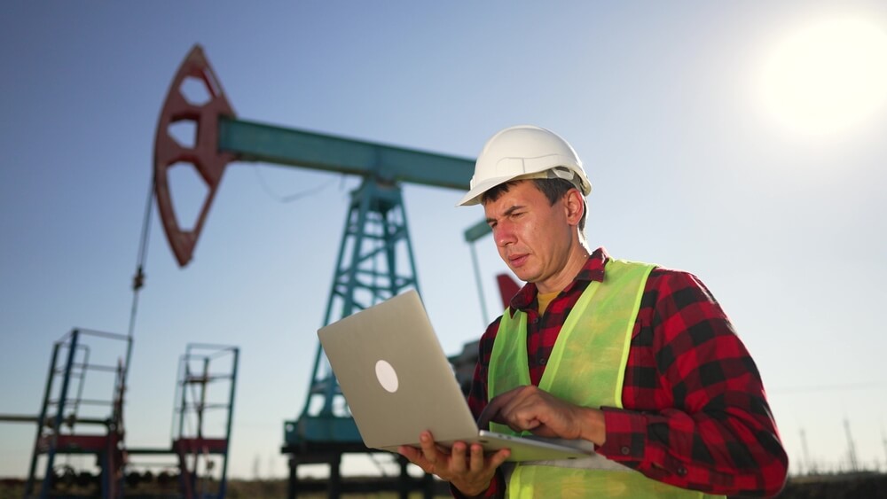 Engineer checking operation of oil pump at plant.