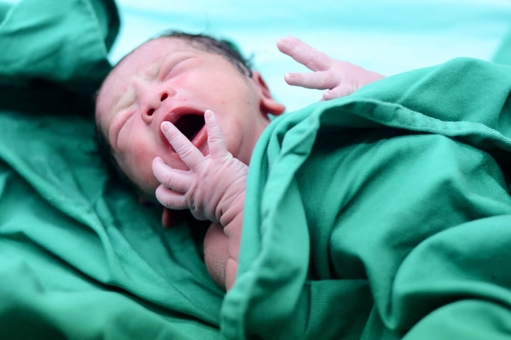 Baby crying after birth in labor room.