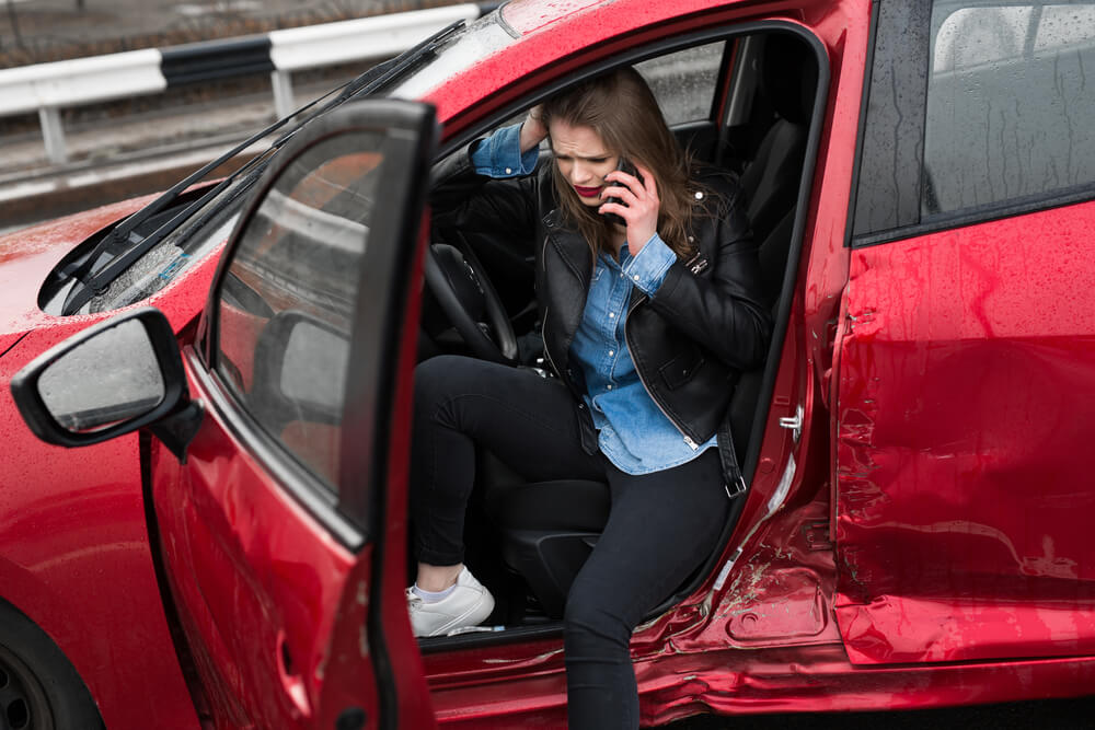 Injured lady driver calling for help to report accident.