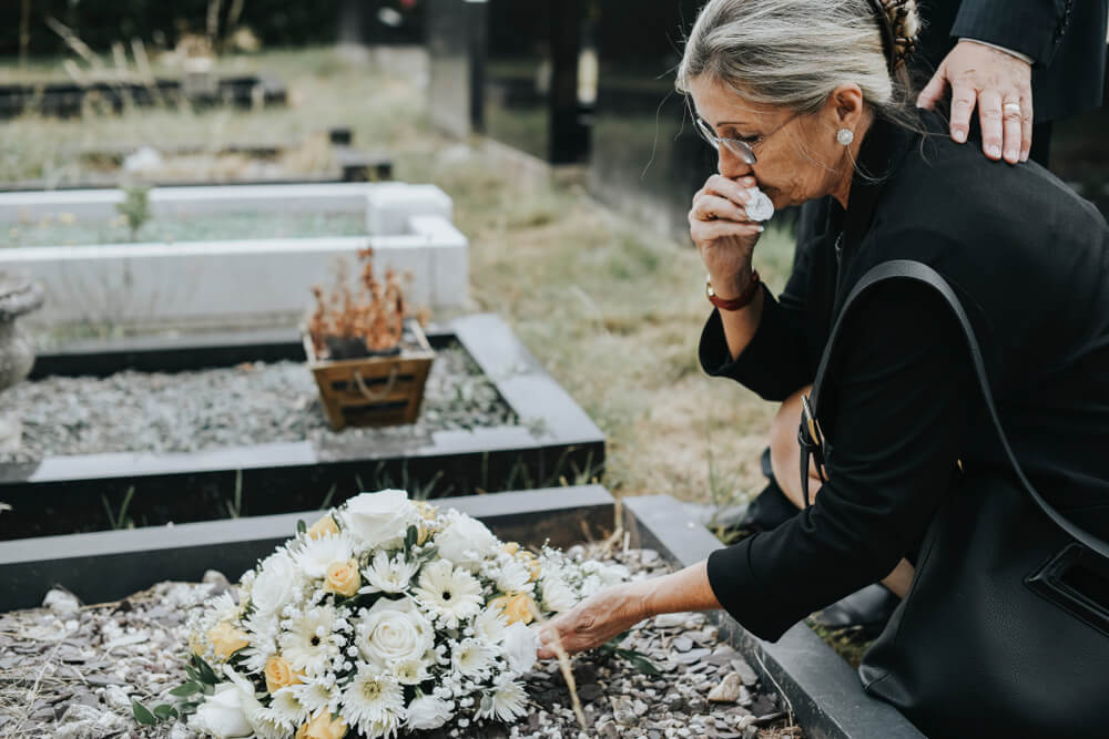 Widow crying at the funeral of her late husband.