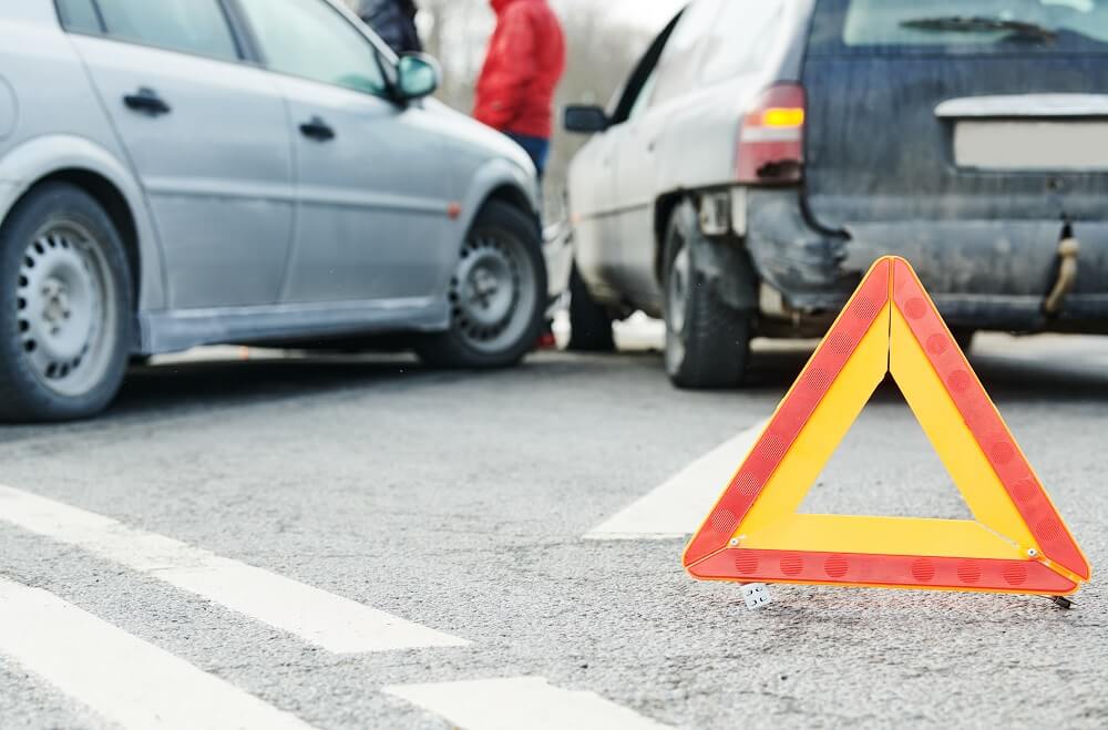 Car accident in the road with warning sign